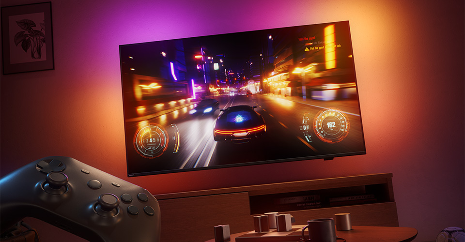 Egy aut&oacute;versenyzős videoj&aacute;t&eacute;kot vet&iacute;tenek egy Philips Ambilight TV-n egy gyeng&eacute;n megvil&aacute;g&iacute;tott szob&aacute;ban