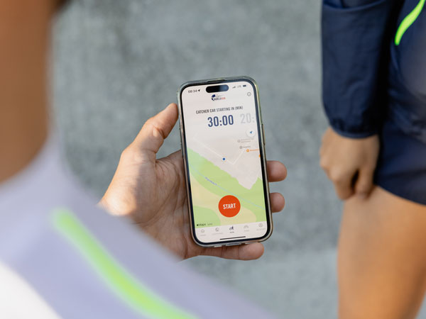 A verseny egyik r&eacute;sztvevője n&eacute;zi a telefonj&aacute;t, &eacute;s v&aacute;rja a fut&aacute;s elind&iacute;t&aacute;s&aacute;t.